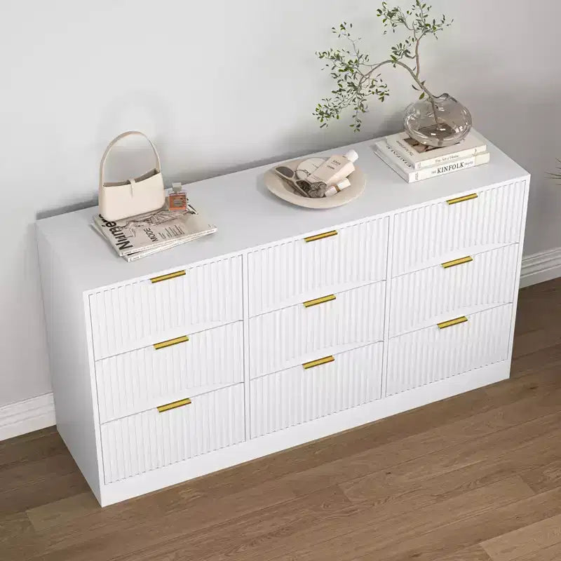 Grand chiffonnier en bois de 160 cm à neuf tiroirs, adapté aux chambres à coucher. Les façades des tiroirs présentent un motif ondulé. Blanc