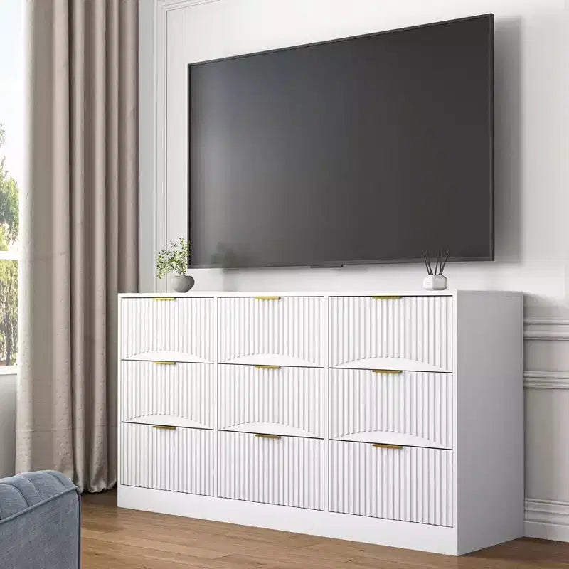 Grand chiffonnier en bois de 160 cm à neuf tiroirs, adapté aux chambres à coucher. Les façades des tiroirs présentent un motif ondulé. Blanc